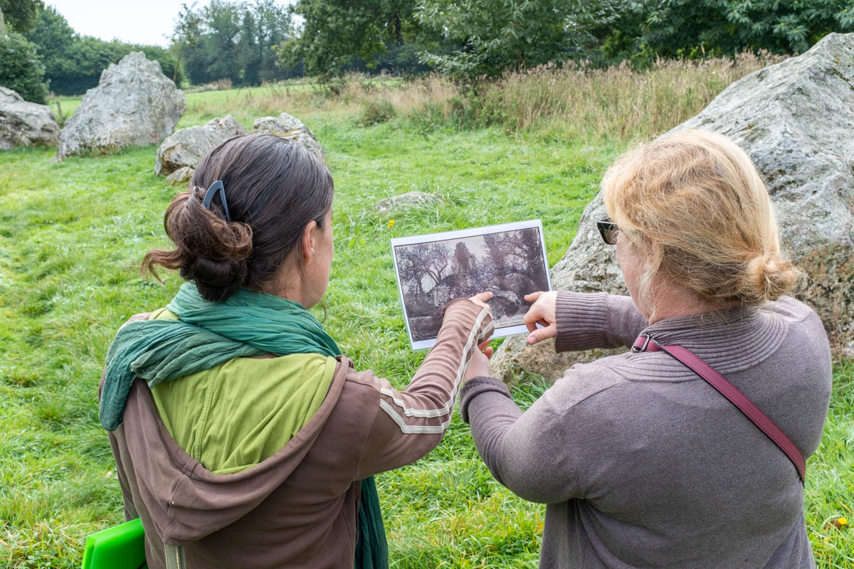 Deux personnes regardent une photo ancienne prise du site mégalithique de Lampouy