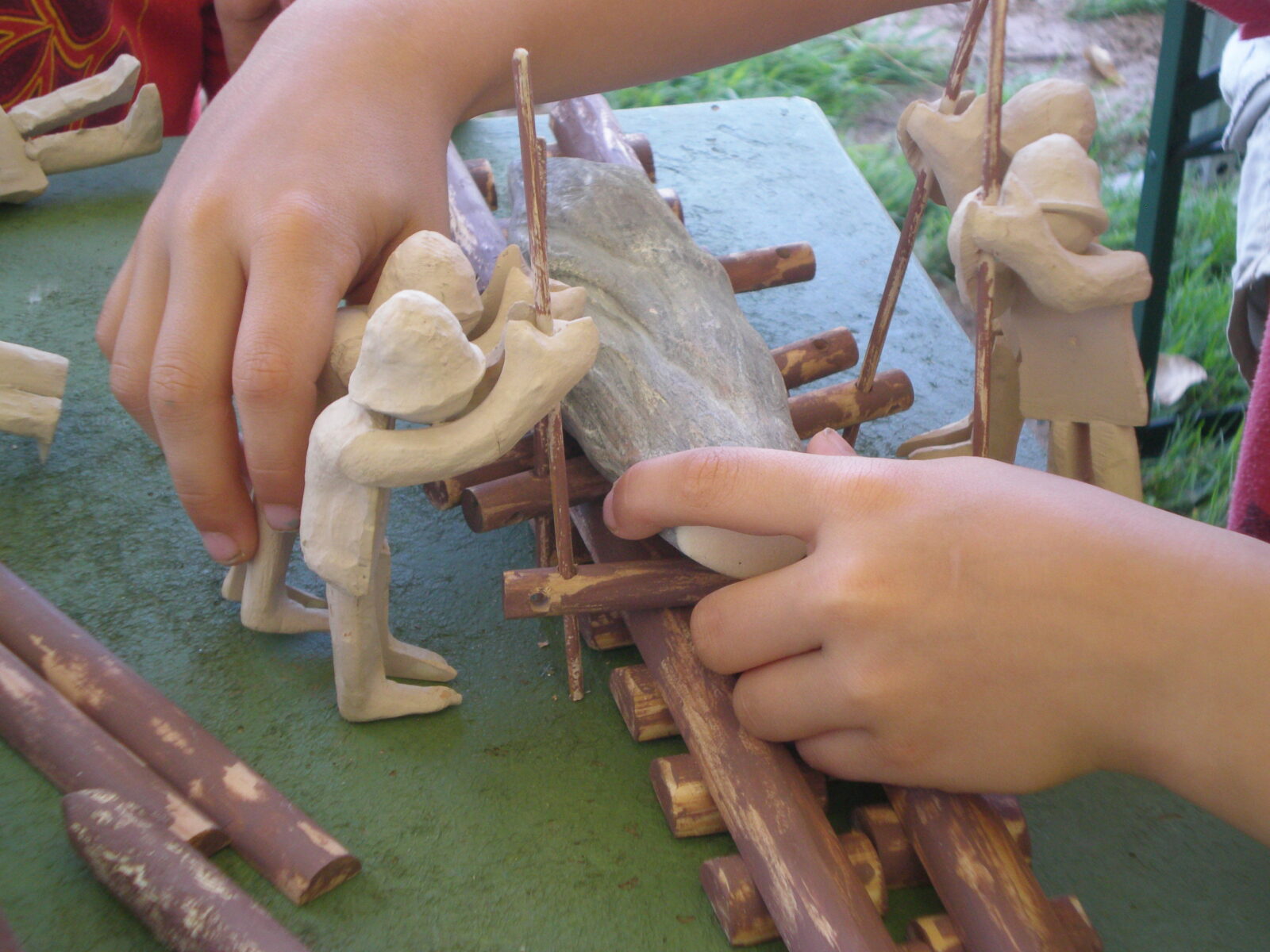 Enfant assemblant les éléments d'une maquette recontistuant un chantier mégalithique