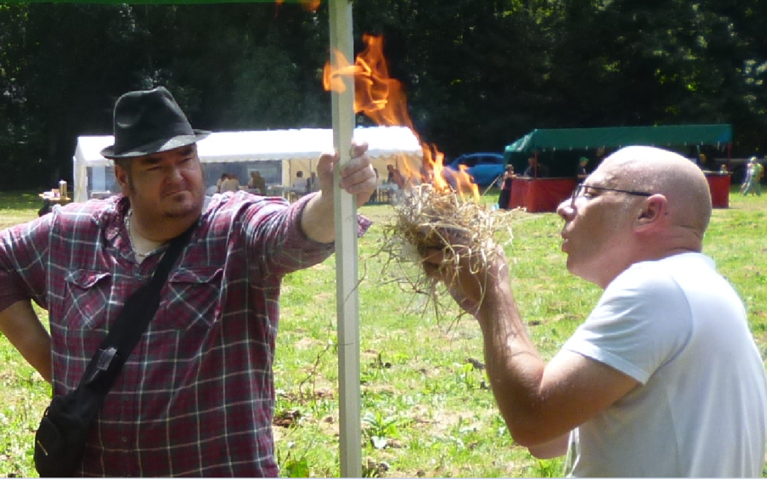 Un homme allume un feu de manière préhistorique.