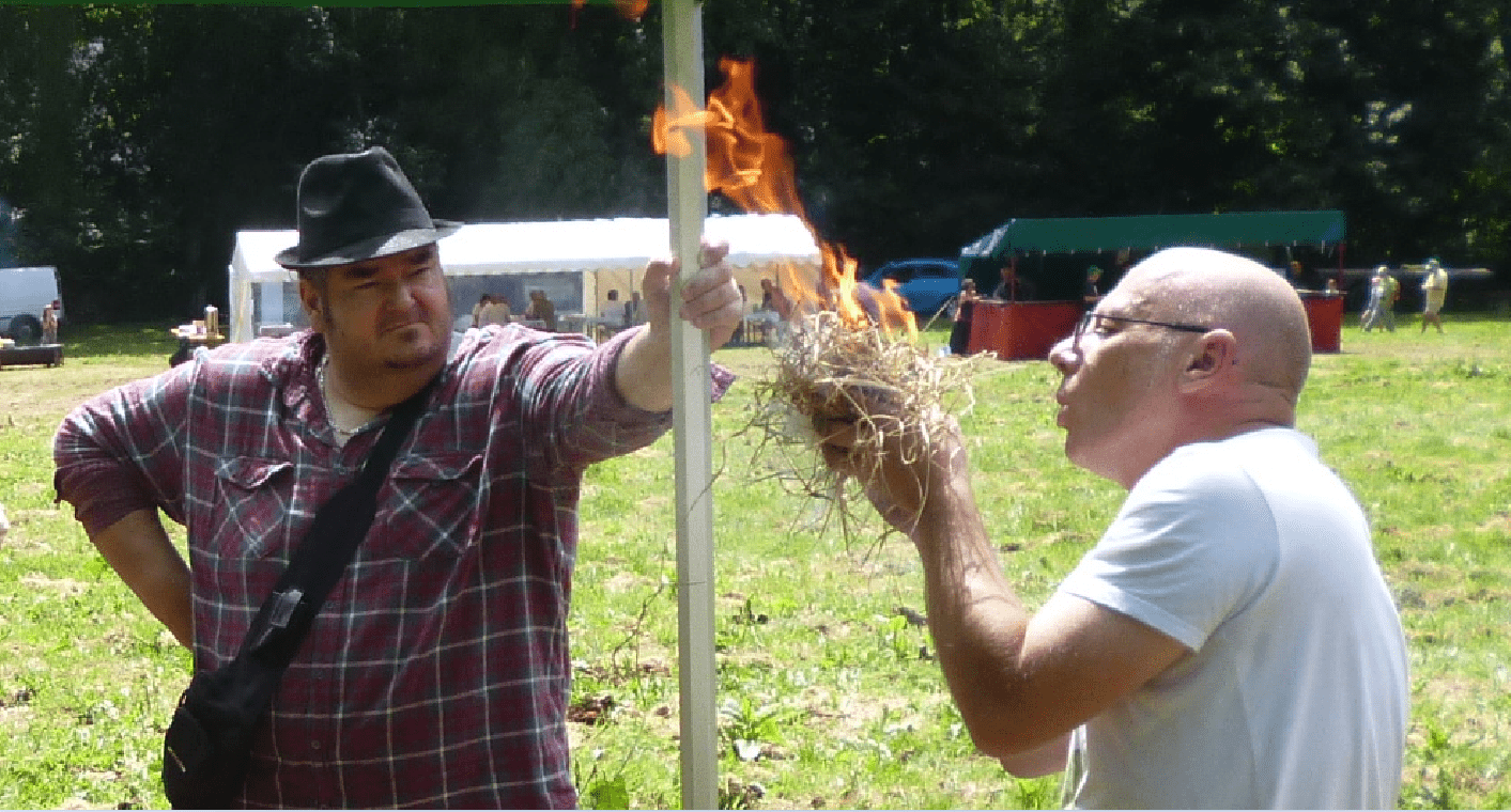 Un homme allume un feu de manière préhistorique.