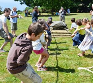 Des enfants déplacent un menhir sur des rondins de bois